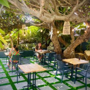 A patio with tables and chairs under a tree at MOY Guesthouse & Backpackers in Cape Town
