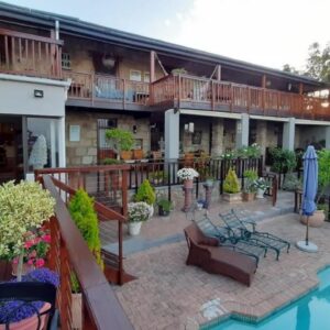A balcony of a hotel with a swimming pool at New Stone Manor in Mossel Bay