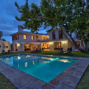A large swimming pool in front of a house at Nova Constantia Boutique Residence in Cape Town