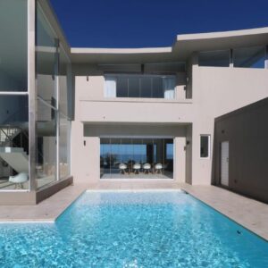 A house with a swimming pool in front of it at Oceans Villa in Wilderness
