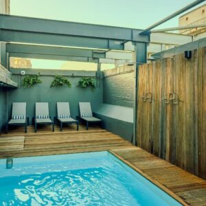 A swimming pool with chairs and a wooden deck at Old Bank Hotel - Lion Roars Hotels & Lodges in Cape Town