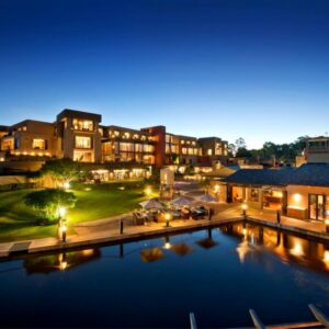 An aerial view of a hotel with a pool at night at Oubaai Hotel Golf & Spa in George