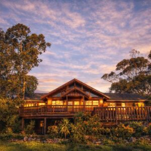 A large wooden house with a large deck at Oyster Creek Lodge in Knysna