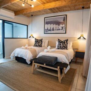 Two beds in a room with wooden ceilings at Paarl Boutique Hotel in Paarl