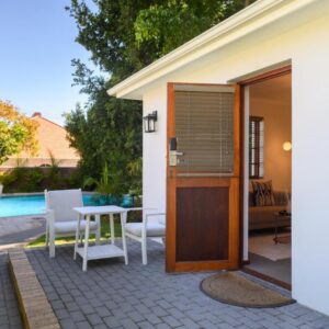 The garden pool and a guest-room doorway at Palm House Boutique Hotel and Spa in Wynberg, Cape Town