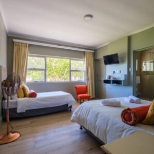 A bedroom with two beds and a mirror at Paternoster Hotel in Paternoster