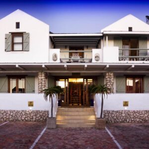 A white house with palm trees in front of it at Paternoster Manor in Paternoster