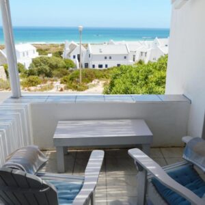 A balcony with a table and chairs and the ocean at Paters Haven Self-catering and B&B in Paternoster