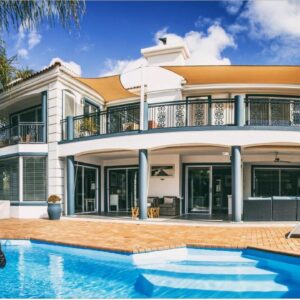 A house with a swimming pool in front of it at Pictures Guest House Boutique Hotel in Oudtshoorn