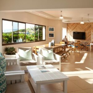A living room with white furniture and a table at Plett Beachfront Guest House in Plettenberg Bay