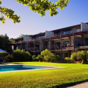 An apartment building with a swimming pool and a yard at Premier Resort The Moorings, Knysna in Knysna