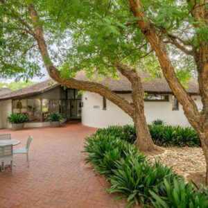 A patio with a table and chairs in front of a house at Protea Hotel by Marriott Oudtshoorn Riempie Estate in Oudtshoorn