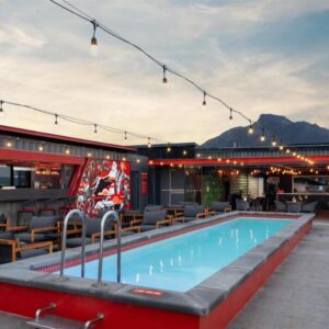 A resort pool with chairs and a bar at Radisson RED Hotel V&A Waterfront Cape Town in Cape Town