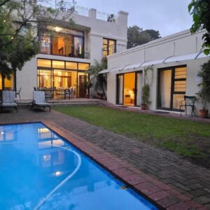 A swimming pool in front of a house at Riversong Guest House in Cape Town