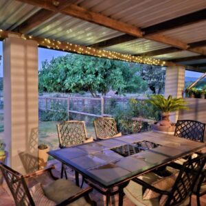 A table and chairs on a patio with lights at Rustic Farmhouse Retreat in Cape Winelands, South Africa in Klapmuts