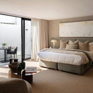 A bedroom with a large bed and a living room at Satori Lodge by Bliss Collection in Cape Town