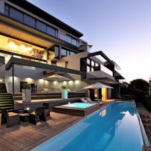 A house with a swimming pool in front of it at Sea Star Rocks Boutique Hotel in Cape Town
