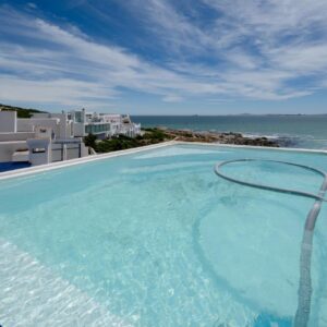 A swimming pool with a view of the ocean at Seehuis Studios in Langebaan