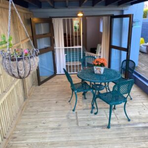 A patio with a table and chairs and a chandelier at Self Catering Luke Drive Onrus in Hermanus