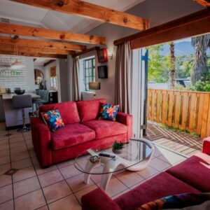 The cottage living room with red sofas at Serenity Cottage in Swellendam