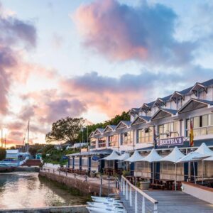 A building with a dock next to a river at Simon's Town Quayside Hotel in Simonʼs Town