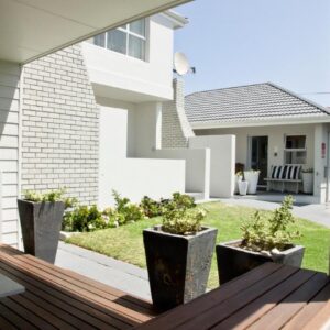 A patio with potted plants on a wooden deck at South Point Guest Lodge in Agulhas