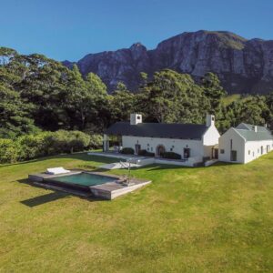 An aerial view of a large white house on a grass field at Southwinds Estate in Hermanus