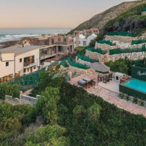 A building on a hill next to the ocean at Spookdraai B&B in Agulhas
