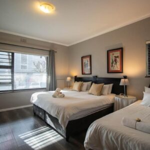 A bedroom with two beds with a teddy bear on them at Spring Tide Inn By Ctha in Cape Town
