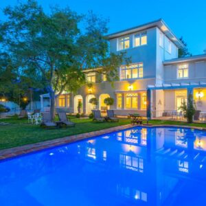 A house with a swimming pool in front of a house at Summerwood Guest House in Stellenbosch