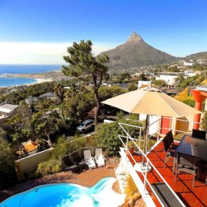 A sun terrace with a pool and views to Lion's Head at Sun Lion Villa in Camps Bay, Cape Town