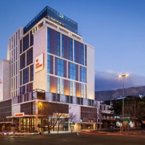 A tall building on a city street at night at SunSquare Cape Town City Bowl in Cape Town