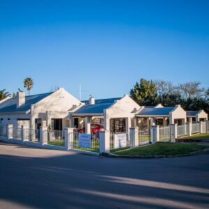 A white fence in front of a white house at Swellendam Self Catering in Swellendam