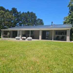 A house with a large lawn in front of it at TAMO Guest Farm in Plettenberg Bay