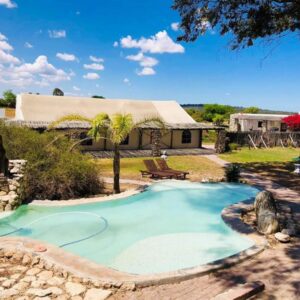 A swimming pool in a yard with a house at Thali Thali Game Lodge in Langebaan