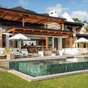 A house with a swimming pool with chairs and umbrellas at The Alexander Estate in Noordhoek