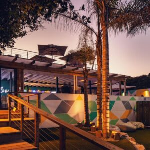 A building with palm trees in front of it at The Bungalow in Plettenberg Bay