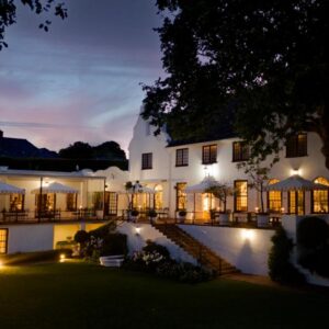 An exterior view of a mansion at night at The Claremont Boutique Hotel in Cape Town
