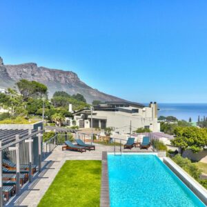 A swimming pool with a view of the ocean at The Crystal Apartments in Cape Town