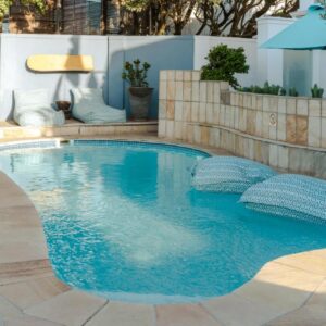 A swimming pool with pillows in a backyard at Last Word Long Beach in Kommetjie