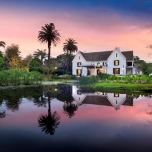 A house with a pond in front of it at The Manor House at Fancourt in George