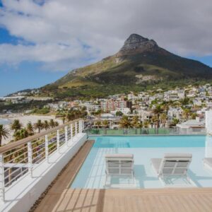 A rooftop pool with sun loungers and a view of Lion's Head at The Marly Boutique Hotel & Spa in Camps Bay, Cape Town