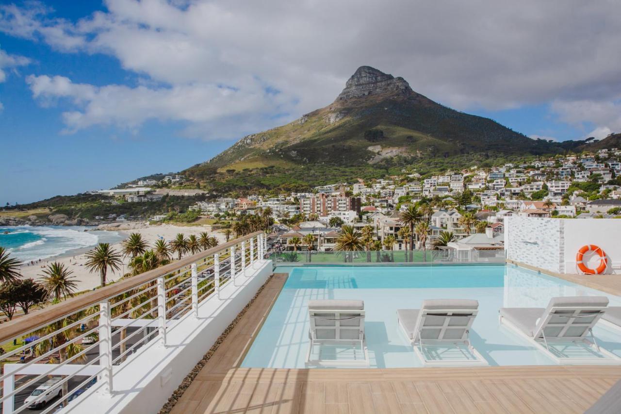 A rooftop pool with sun loungers and a view of Lion's Head at The Marly Boutique Hotel & Spa in Camps Bay, Cape Town