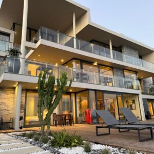 An apartment building with two chairs and a patio at The Ocean View Guest House in Wilderness