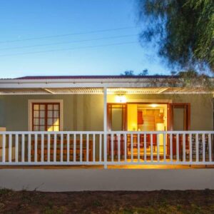 A house with a porch and a deck at The Ostrich Barons Cottages in Oudtshoorn