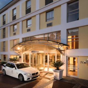 A white car parked in front of a building at The Portswood Hotel in Cape Town