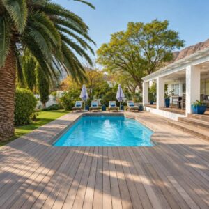 A backyard with a pool and a house with a palm tree at theLAB BLUE in Franschhoek