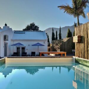 A swimming pool in front of a house with a fence at theLAB Franschhoek in Franschhoek