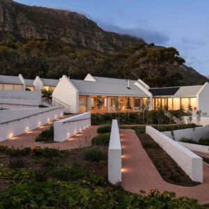 White cottages and lit garden paths below the mountain at dusk at Umoya Residence in Hout Bay