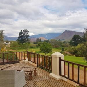 A wooden deck with a table and an umbrella on it at Val d'Or Estate in Franschhoek
